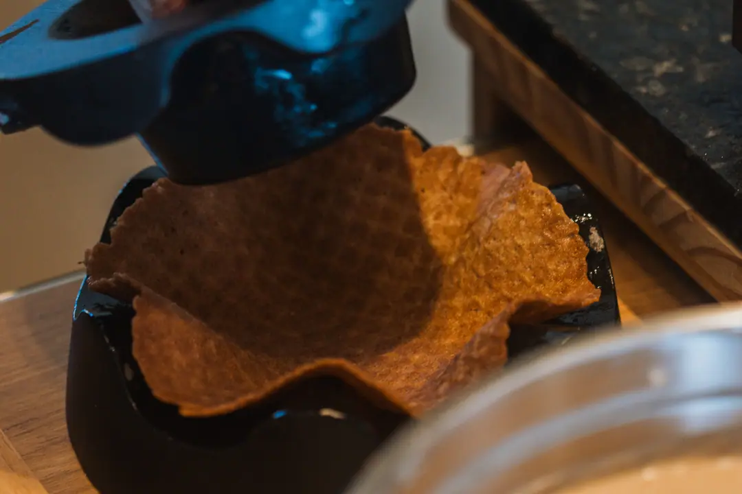 Biscoito ainda mole sendo moldado em forma de cestinha